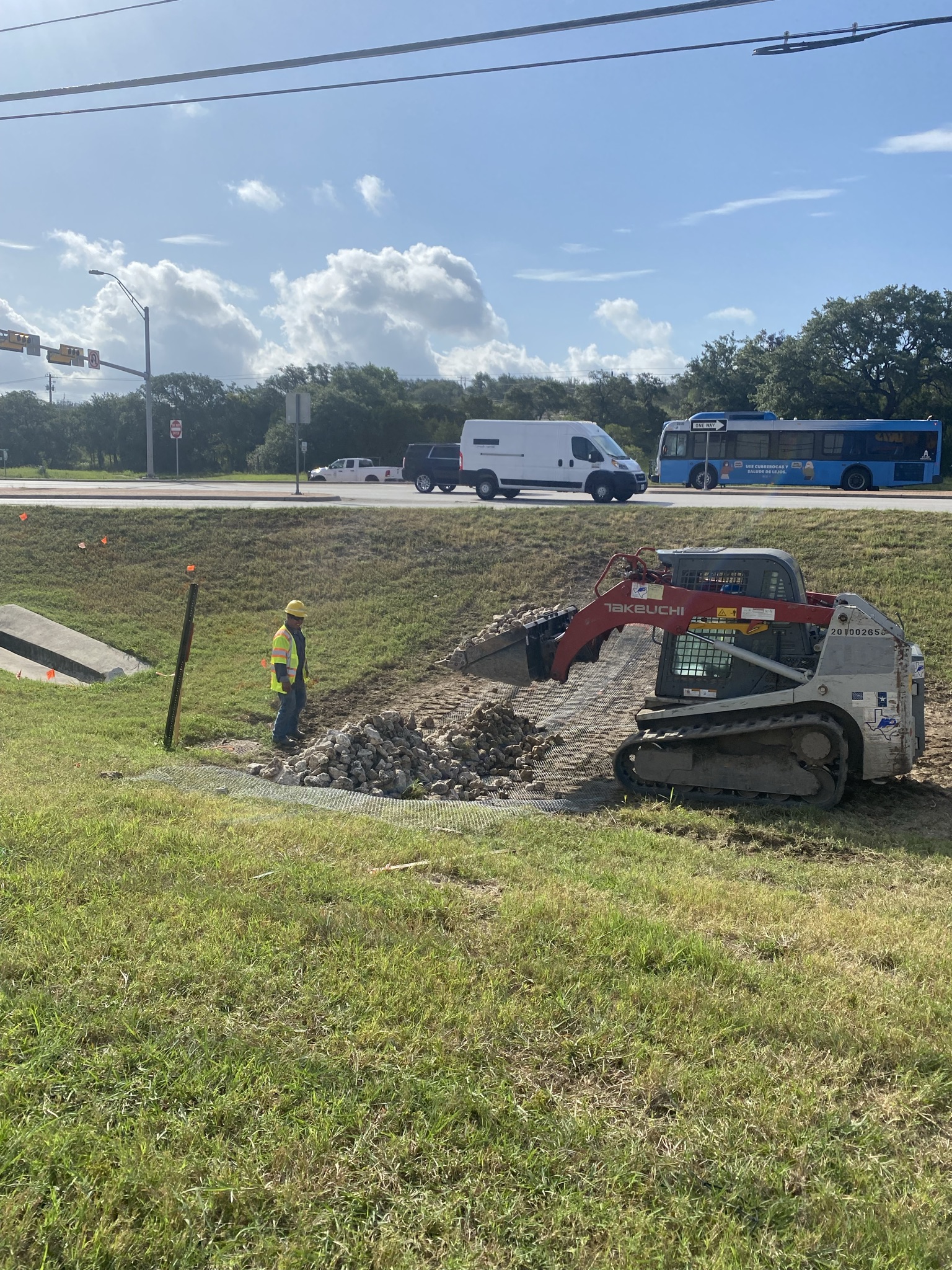 Crews install a rock filter dam near the US 290/SH 71 “Y” interchange, one of the many stormwater best management practices being used to protect the Edwards Aquifer during construction, August 2021